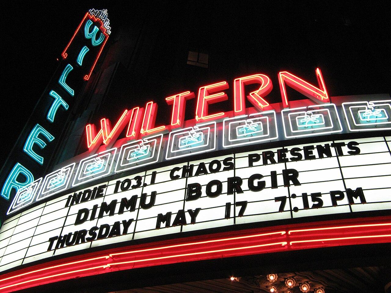 The Art Deco Wiltern Theatre and Pellissier Building lit up at night on Wilshire Boulevard